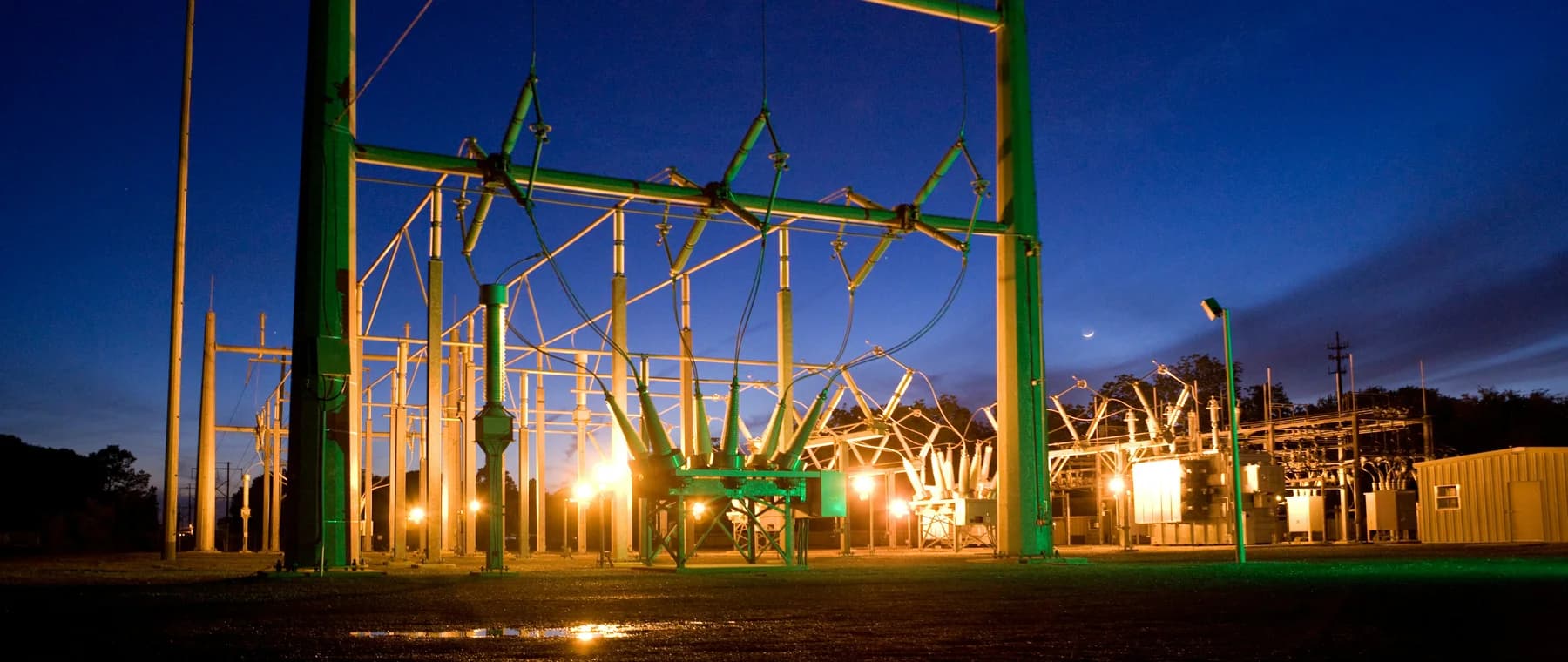 An electrical substation with transmission towers at dusk